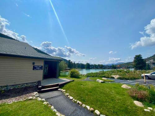 a building with a grass yard next to a body of water at Montezuma 1770 by SummitCove Lodging in Keystone