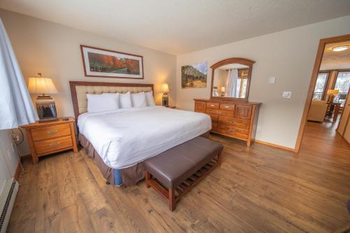 a bedroom with a large bed and a mirror at Montezuma 1770 by SummitCove Lodging in Keystone