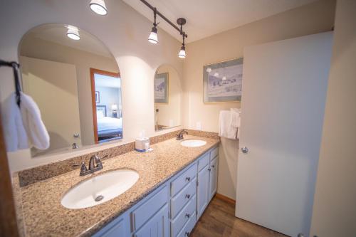 a bathroom with two sinks and a large mirror at Montezuma 1770 by SummitCove Lodging in Keystone