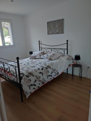 une chambre avec un lit avec une couette fleurie dans l'établissement Grand F2 vue montagne, à Olmeta-di-Tuda