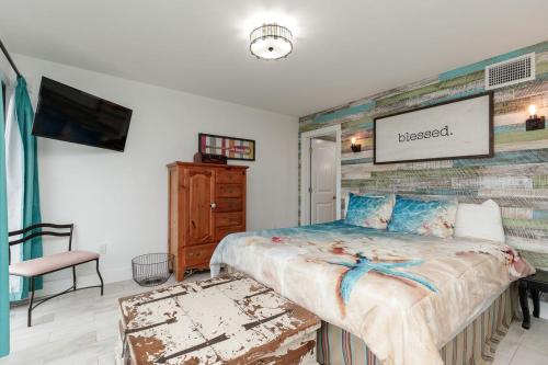 a bedroom with a large bed and a tv at Island House BeachFront Condo Hotel in Corpus Christi