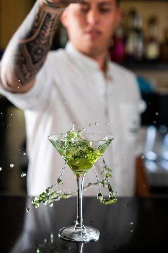 a man is pouring a drink into a martini glass at Borralha Hotel, Restaurante & Spa in Vila Real