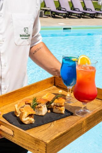 a tray of food and drinks on a table by a pool at Borralha Hotel, Restaurante & Spa in Vila Real