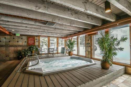 a hot tub on a wooden deck with plants at Lakeside 1476 by SummitCove Lodging in Keystone