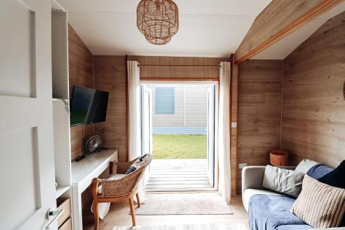a small living room with a couch and a window at Oldwalls Gower in Llanrhidian