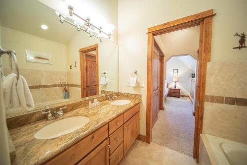a bathroom with two sinks and a large mirror at Antlers Gulch 502 by SummitCove Lodging in Keystone