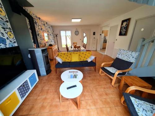 a living room with a yellow couch and a table at L'abri in Trémuson