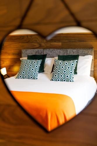 a bed is seen through a heart shaped mirror at Oldwalls Gower in Llanrhidian