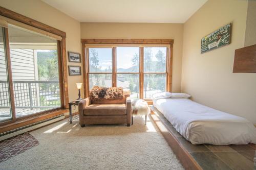a bedroom with a bed and a chair and a window at Quicksilver 1639 by SummitCove Lodging in Keystone