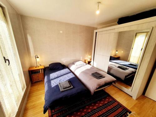 une chambre avec deux lits et un grand miroir dans l'établissement La fleur de lys, à Plérin