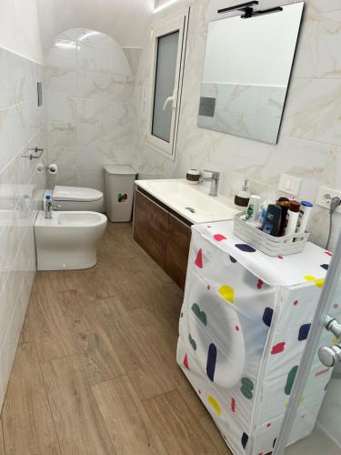 a bathroom with a sink and a toilet and a mirror at Appartamento Il Dammuso in Marsala
