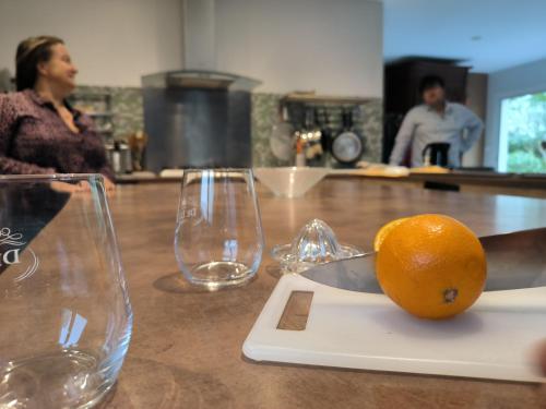 une orange sur une planche de découpe sur un comptoir avec des verres dans l'établissement Lou barede, à Montagne