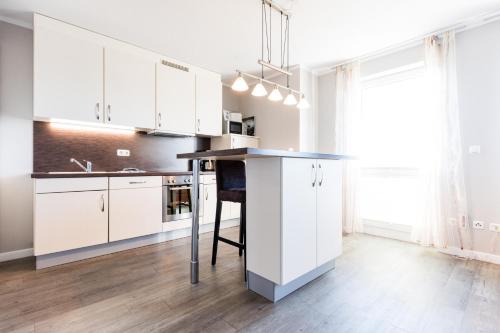a kitchen with white cabinets and a black counter top at Fehmarnstrand 78 App 12 in Staberdorf