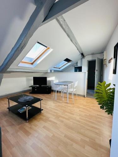 - un salon mansardé avec une table et des chaises dans l'établissement Le musée, à Charleville-Mézières