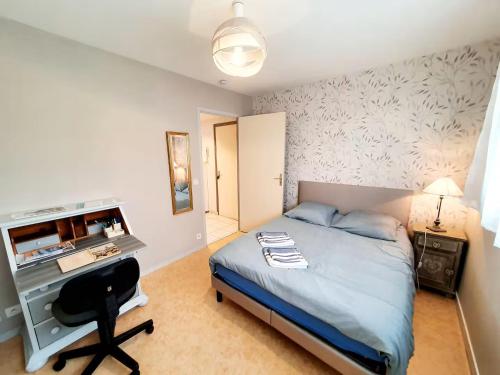 une chambre avec un lit, un bureau et un ordinateur dans l'établissement Le rêve marin, à Plérin