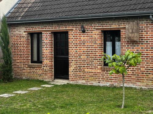 a brick house with a small tree in front of it at Hôtel de l image in Vouzon