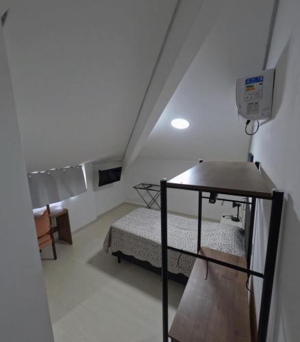 a small room with a bed in a attic at HAUSHostel in Vinhedo