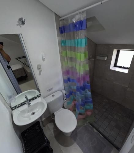 a bathroom with a sink and a toilet and a shower at HAUSHostel in Vinhedo