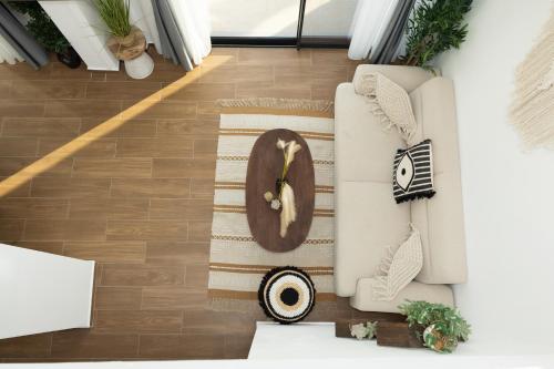 a living room with a clock on a couch at Flamingo Living Halkidiki - The Villas in Áyios Mámas