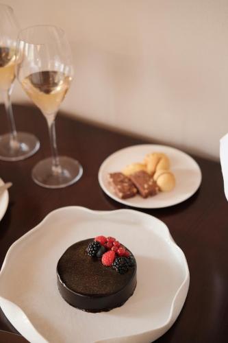 a chocolate dessert on a plate on a table with wine glasses at Hotel Villa Cipressi, by R Collection Hotels in Varenna