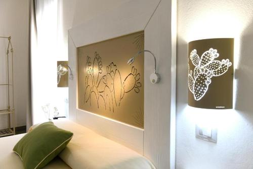 a bedroom with a bed with a lamp on the wall at Alghero Sunrise in Alghero