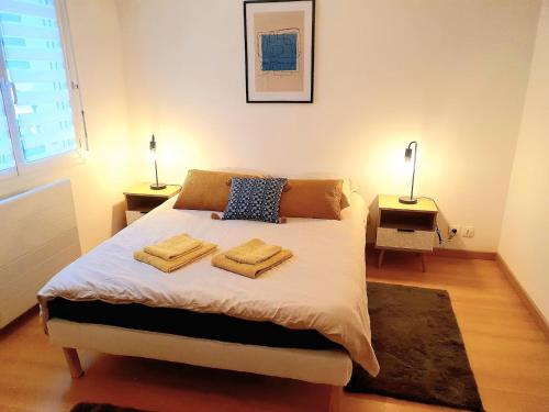 a bedroom with a bed with two towels on it at Le 4 saisons - Terrasse avec vue mer panoramique in Saint-Brieuc
