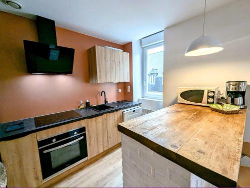 une cuisine avec un comptoir en bois et un évier dans l'établissement Cathédrhalte - Le coeur historique, à Saint-Brieuc