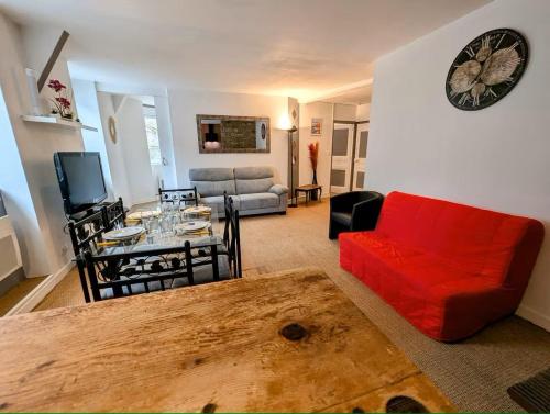 un salon avec un canapé rouge et une table dans l'établissement Cathédrhalte - Le coeur historique, à Saint-Brieuc