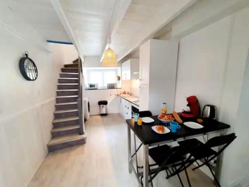 une cuisine avec une table et des chaises ainsi qu'un escalier dans l'établissement Le port Favigo, à Plérin