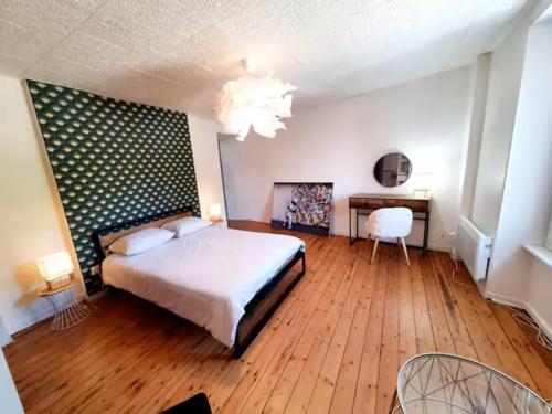 - une chambre avec un lit et un bureau avec une table dans l'établissement Le port Favigo, à Plérin