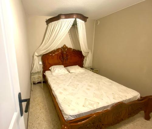 une chambre avec un lit à baldaquin dans l'établissement Famille & Farniente - Terrasse verdoyante au couchant, à La Grande Motte