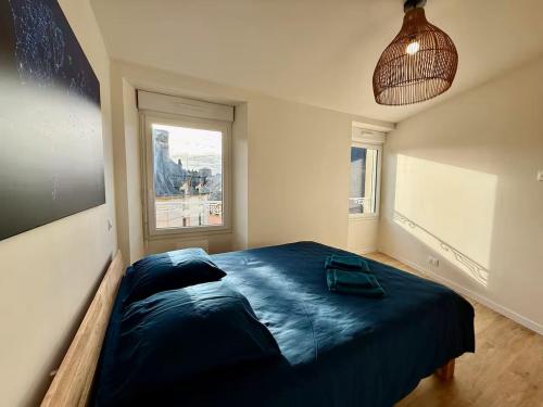 - une chambre avec un grand lit dans une pièce dotée d'une fenêtre dans l'établissement Coeur de ville, à Saint-Brieuc