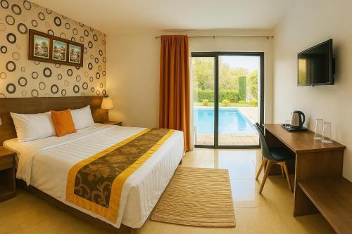 a hotel room with a bed and a desk and a television at Welcome Inn in Grand Baie