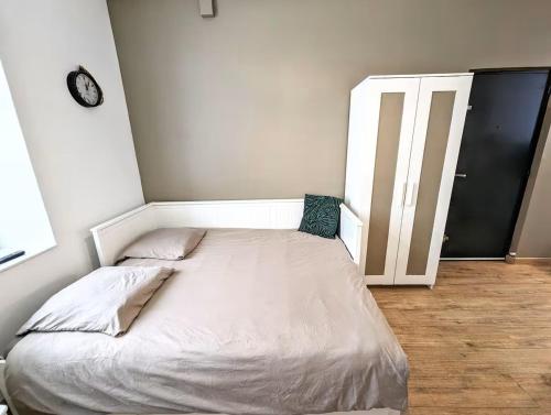 Ce lit se trouve dans un dortoir doté d'une horloge murale. dans l'établissement Le Nid - studio cosy fraîchement rénové, à Saint-Brieuc