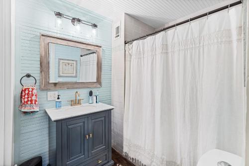 a bathroom with a sink and a shower curtain at Drackett House by Whiskey Properties in Bay Saint Louis