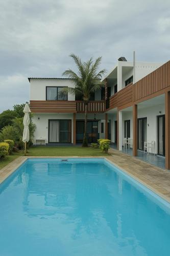 a house with a swimming pool in front of a house at Welcome Inn in Grand Baie