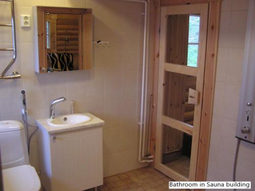 a bathroom with a sink and a toilet and a shower at Spacious villa with great scenery and nature in Pertunmaa