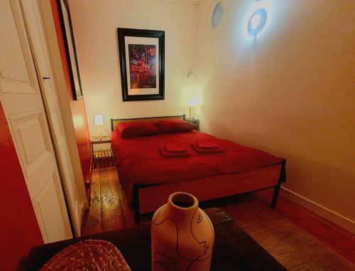 - une petite chambre avec un lit rouge et un canapé dans l'établissement Chez Jeanne, à Saint-Brieuc