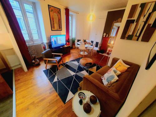 un salon avec un canapé et une télévision dans l'établissement Chez Jeanne, à Saint-Brieuc