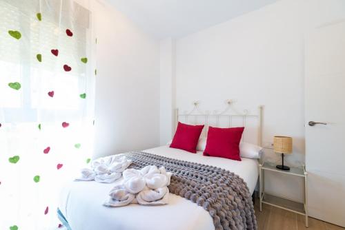 Un dormitorio con dos camas con almohadas rojas. en Coqueto apartamento en Realejo, en Granada