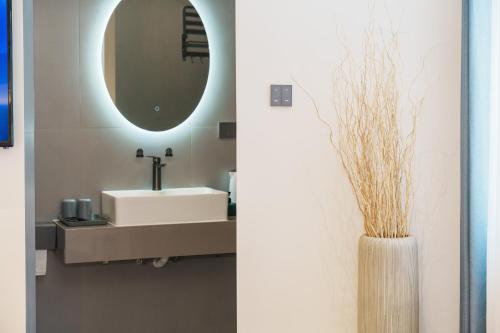 a bathroom with a sink and a mirror at Gafanmeisu in Fenghuang