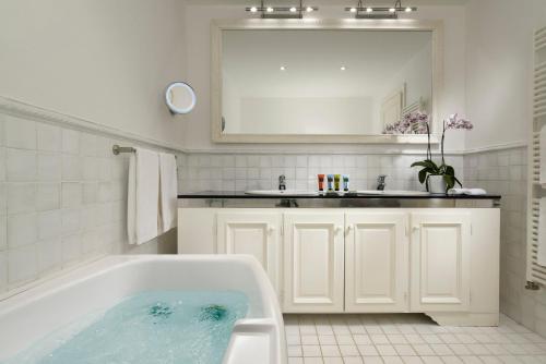 a white bathroom with a tub and a sink at Hotel Piccolo Sant'Andrea in Praiano