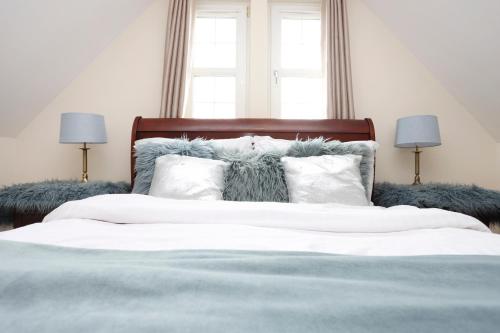 a bedroom with a bed with white sheets and pillows at JOIVY Greenknowes Estate with Hot Tub and Bar - Farmhouse and Lodge in Kelty
