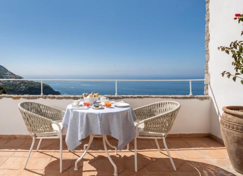 a table and chairs with a view of the ocean at Hotel Piccolo Sant'Andrea in Praiano