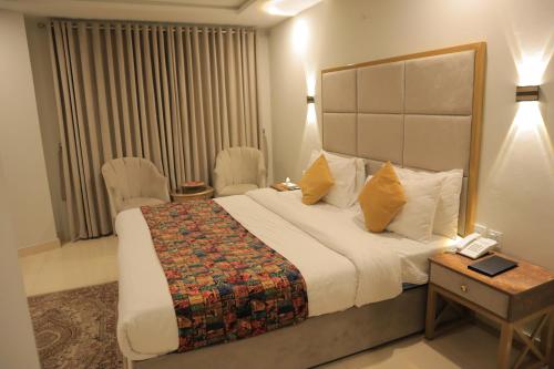 a hotel room with a bed and a table and chairs at Destination Hotel Murree in Murree