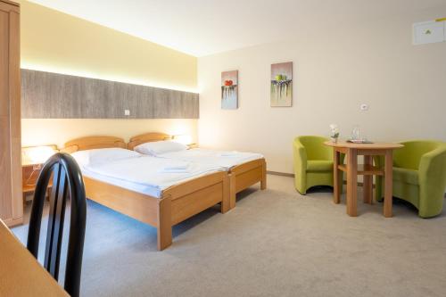 a bedroom with a bed and two green chairs at Vila Sofia in Tržič