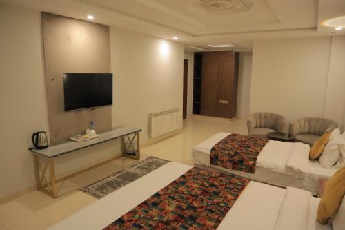 a hotel room with two beds and a flat screen tv at Destination Hotel Murree in Murree