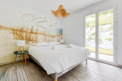 une chambre avec un lit et un tableau au mur dans l'établissement LEGARREKO BIDEA Beautiful house with a pool between land and sea, à Larressore