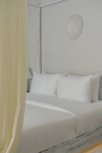 a white bed with white pillows and a window at O - HO Boutique Home in Baan Tai