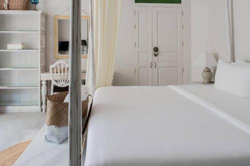 a white bedroom with a bed and a chair at O - HO Boutique Home in Baan Tai